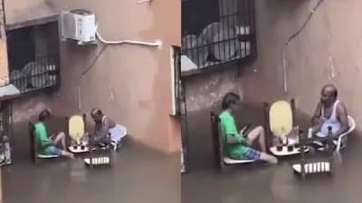 Two Men Enjoy Drinks In Knee Deep Water Amid Heavy Rain in Mumbai