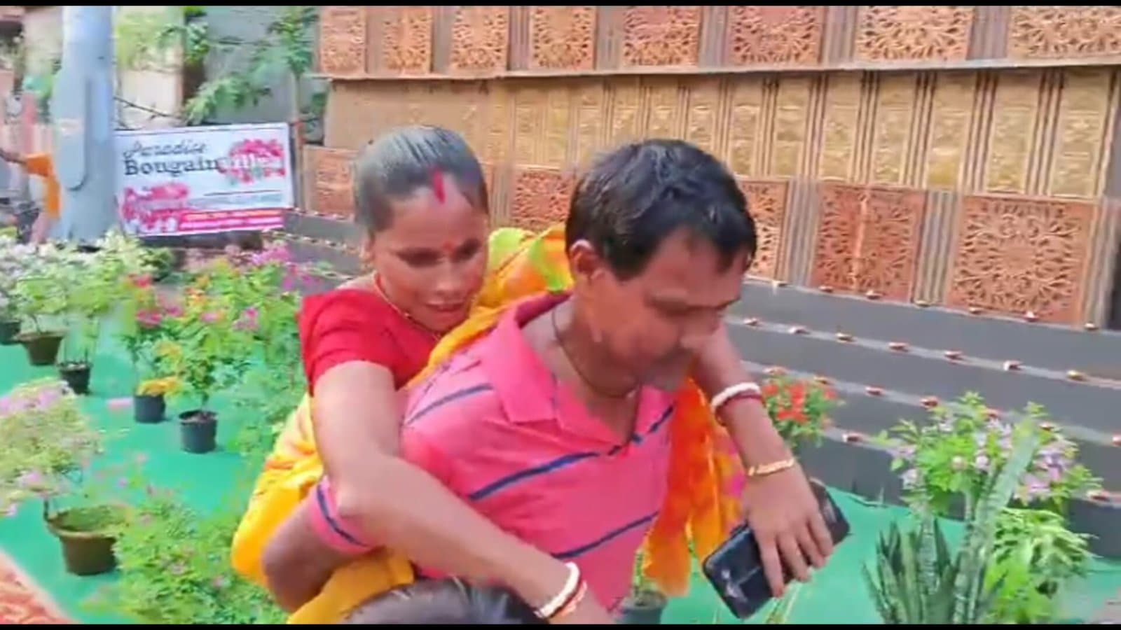 পঙ্গু স্ত্রীকে পিঠে করে নিয়ে ঠাকুর দেখাচ্ছেন স্বামী