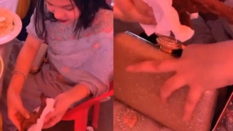 Woman caught putting chicken leg inside vanity bag in viral video