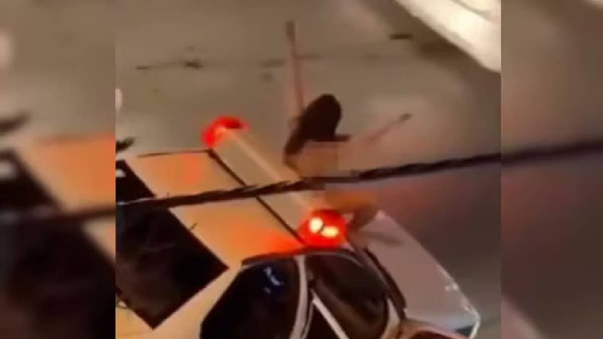 naked woman jumping on police car in protest of iranian oppressive clothing laws 